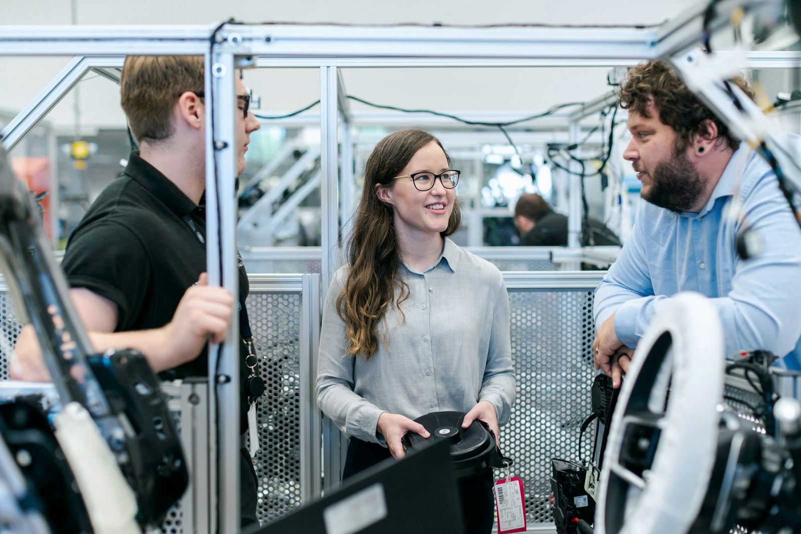 Engineer in glasses discussing a test set-up with two colleagues